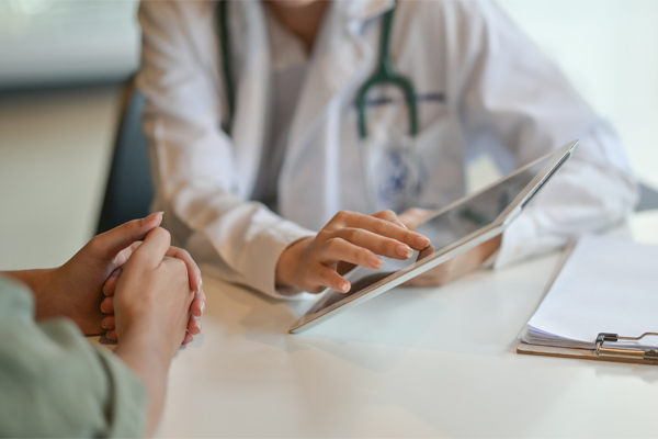 Close up of a doctor in a white coat presenting a tablet to a patient. Receive concierge medicine care from AZENA Health & Longevity in Gainesville.