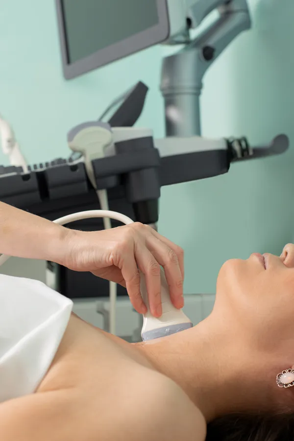 Hashimotos-Thyroiditis-Treatment A woman gets a thyroid scan from a doctor in a clinic. Get help with Hashimoto's Thyroiditis from AZENA Health & Longevity in Gainesville.