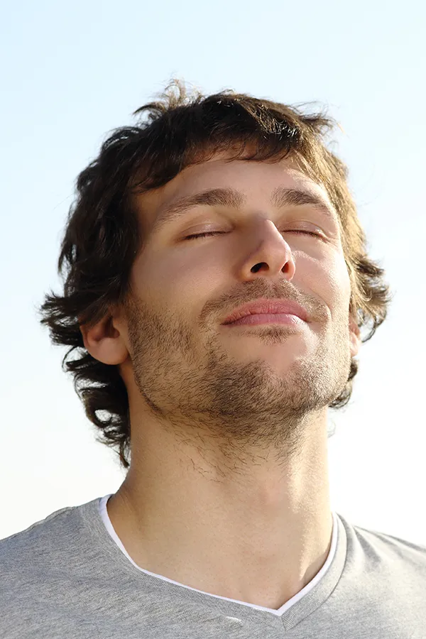 Lupus-Treatment A brown-haired man closes his eyes and breathes in fresh air with his face turned up to the sky. Get treatment for Lupus from AZENA Health & Longevity in Gainesville.