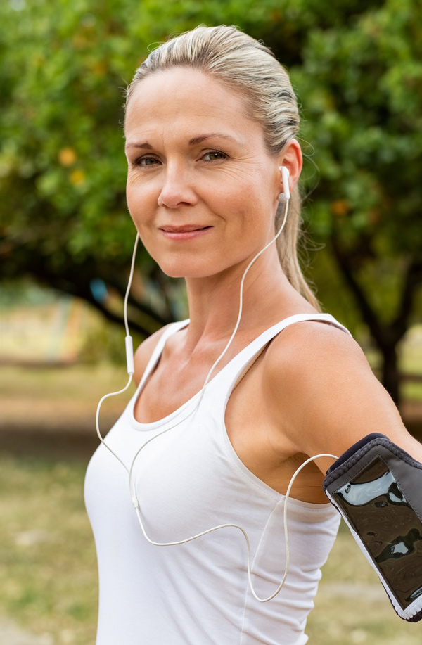 fibromyalgia-doctor Middle-aged, active woman taking a break to smile at the camera during a run, representing successful Bioidentical Hormones for Fibromyalgia Relief offered by AZENA Health & Longevity in Gainesville.